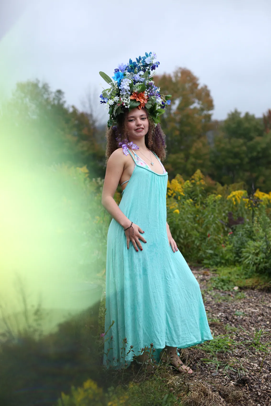 Full-length pose in a turquoise dress and blue crown
