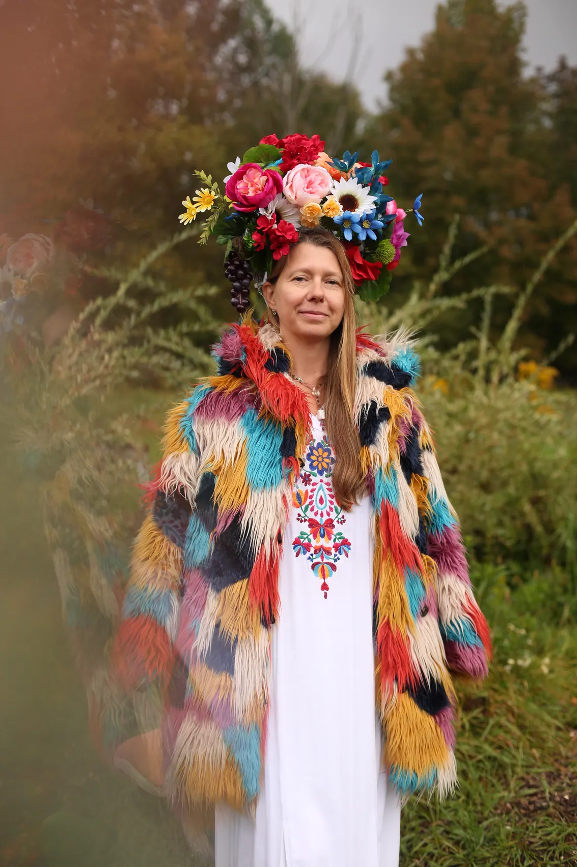 Full-length pose in a rainbow fur coat and a bright multicolour crown