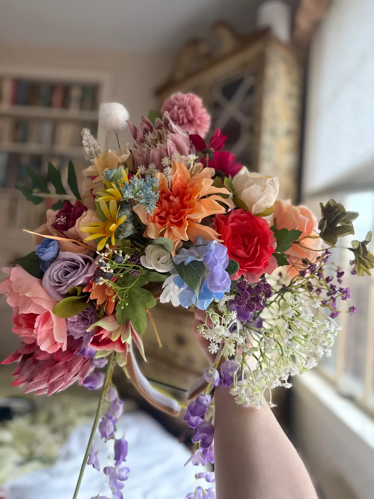 A finished floral headdress dense with roses, dahlias and hydrangea